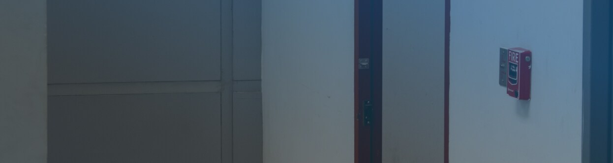 A call point unit near a fire exit door in an office