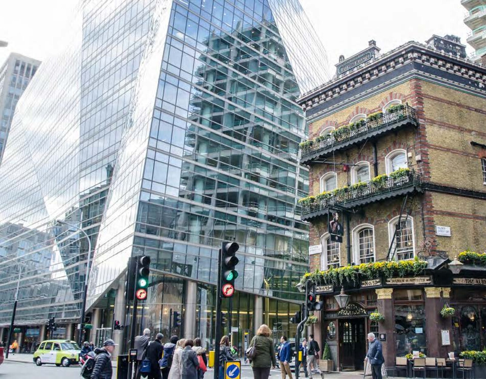 People walking along a crowded street lined with commercial buildigs